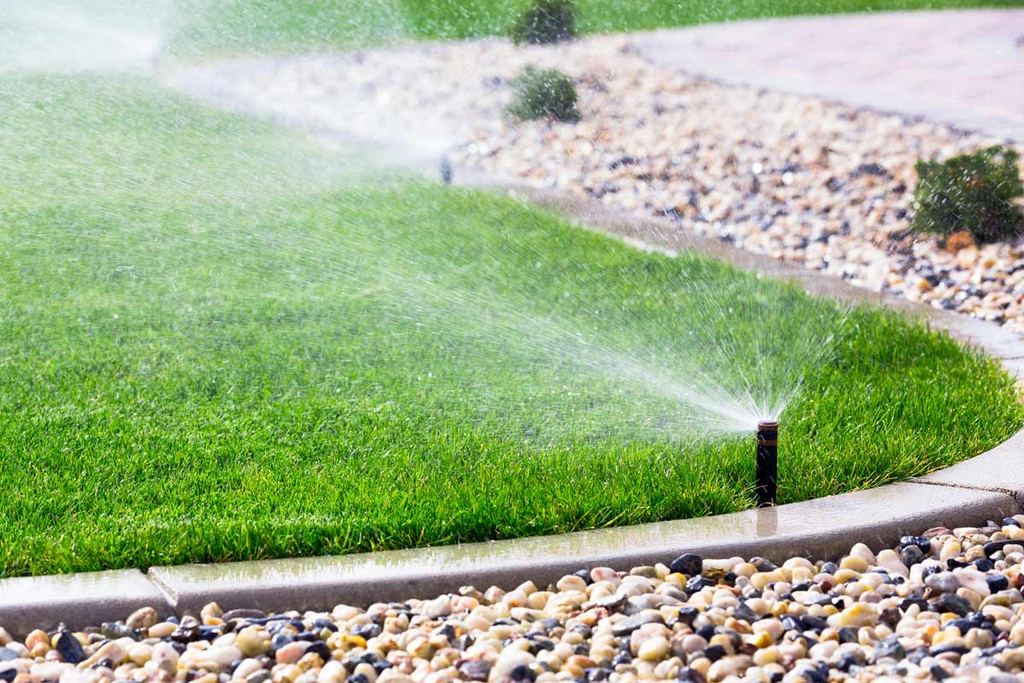 Residential irrigation operating across a healthy lawn